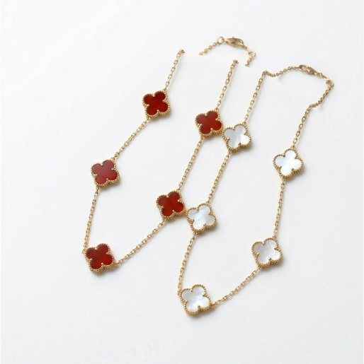 Gold necklaces with clover-shaped pendants on a white background