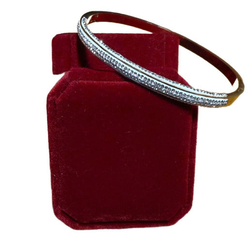 The brilliant zircons create a continuous sparkle, beautifully contrasting with the visible gold framework at the ends of the bangle.