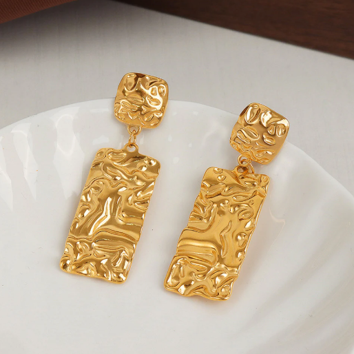 Each earrings consist of two geometric sections: a smaller, squarish top piece and a larger, rectangular bottom piece connected by a small jump ring.