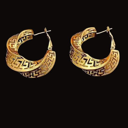 Pair of gold hoop earrings with intricate designs on a black background