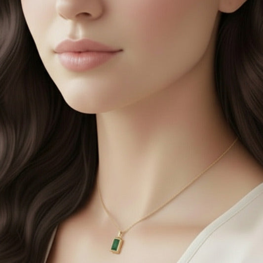 Beautiful and elegant gold plated necklace featuring a striking rectangular, emerald-cut green gemstone pendant.  This necklace is a classic example of fine jewelry, exuding timeless appeal.