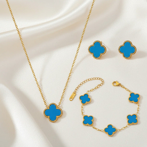 Jewelry set with blue clover-shaped pendants on gold chains.