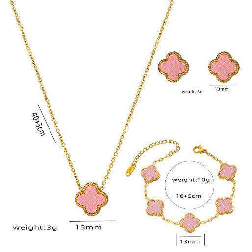 Jewelry set with pink clover-shaped pendants including necklace, bracelet, and earrings on a white background.