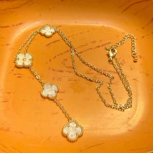 Gold necklace with clover-shaped pendants. This is a necklace in lariat configuration, allowing the chain to drape elegantly.