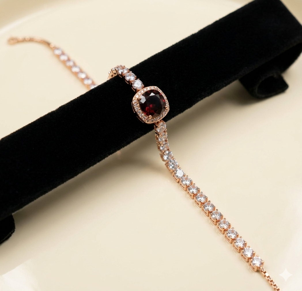 Rose gold tennis bracelet with a red gemstone on a black velvet stand.