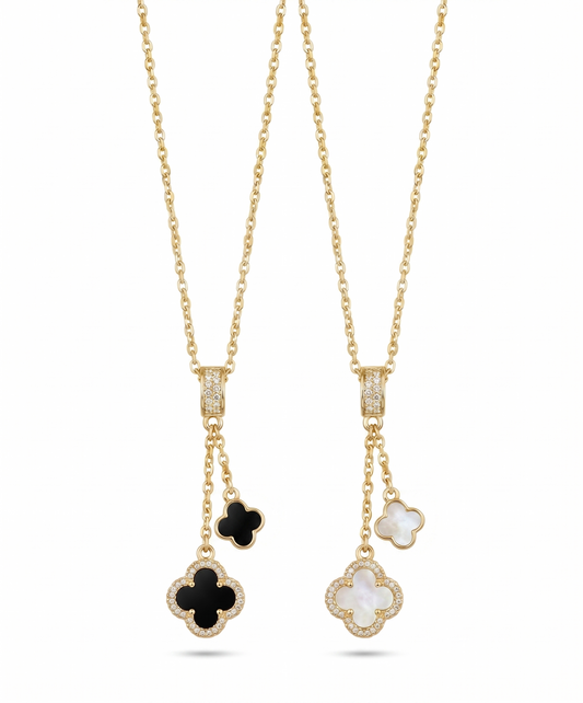 Two gold necklaces with clover-shaped pendants on a white background