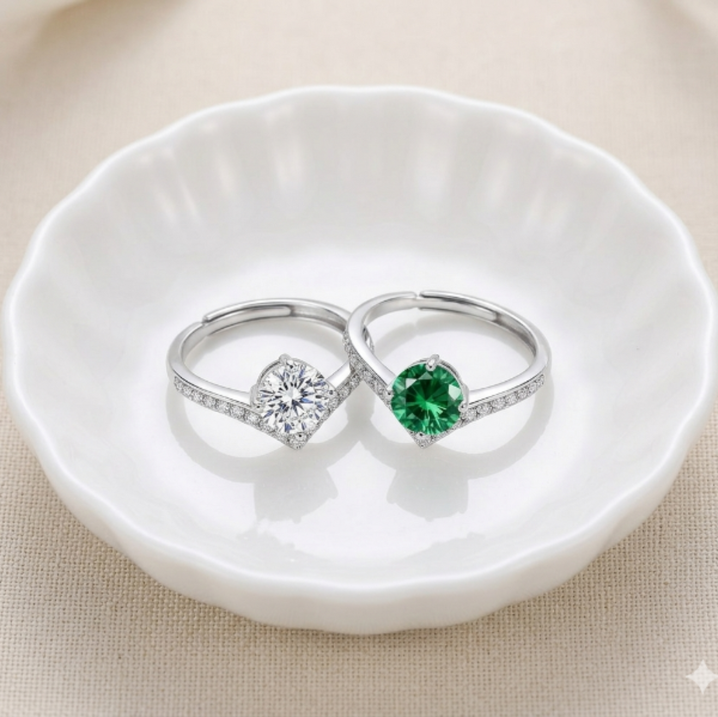 Two silver rings with moissanite gemstones and V shaped band  on a white dish