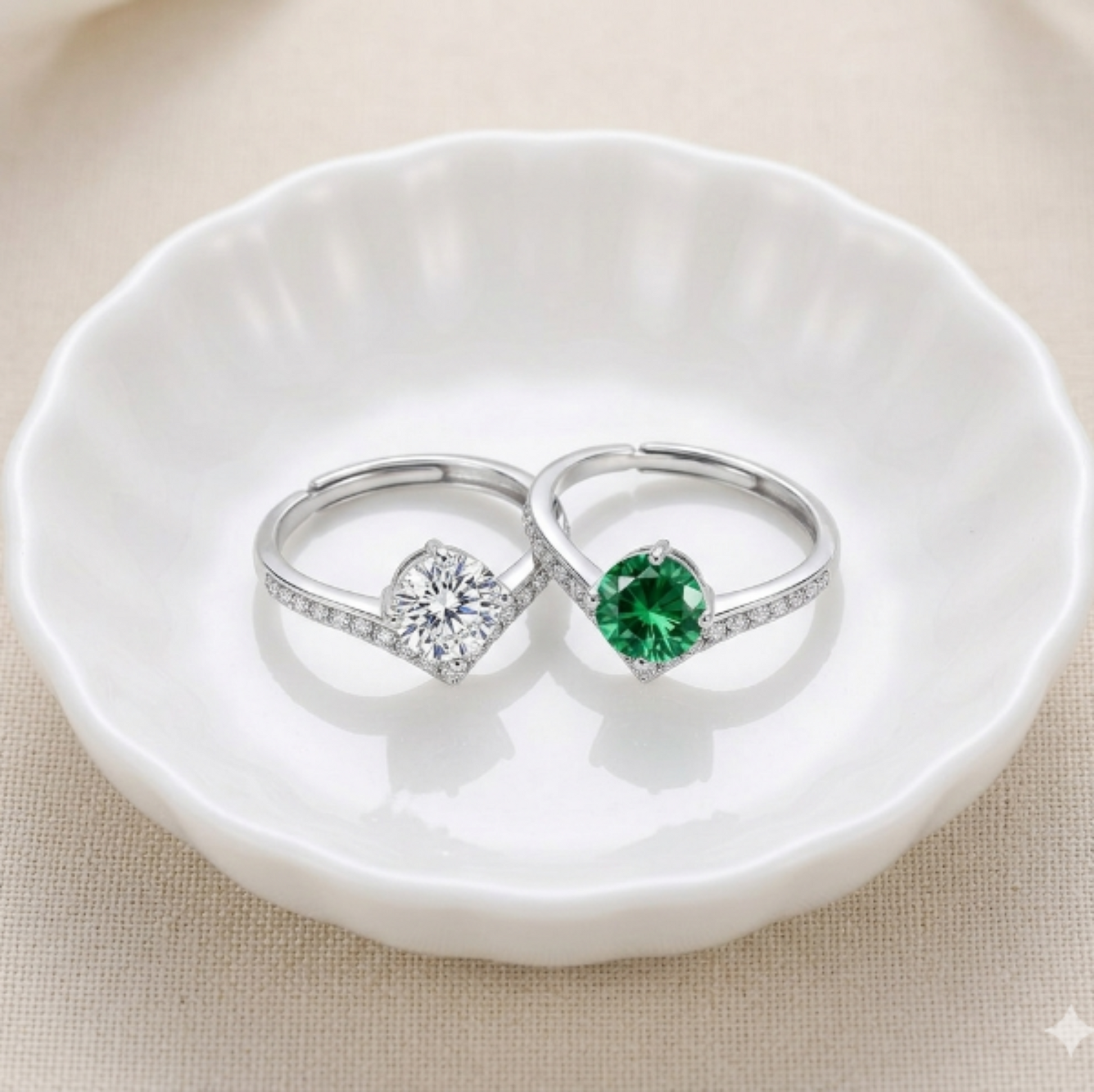 Two silver rings with moissanite gemstones and V shaped band  on a white dish