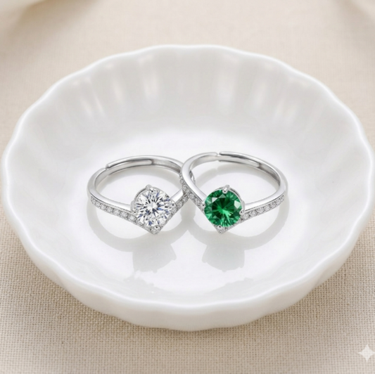 Two silver rings with moissanite gemstones and V shaped band  on a white dish