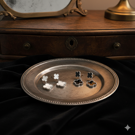 Two elegant pairs of qua-trefoil double drop earrings, in a silver-toned metal, with a distinctive ridged edge around the clovers.