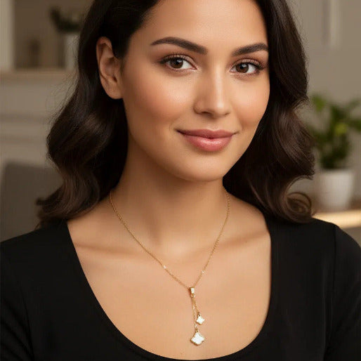 Y-drop style necklace, with a gold-tone chain and two clover pendant in white enamel finish. 