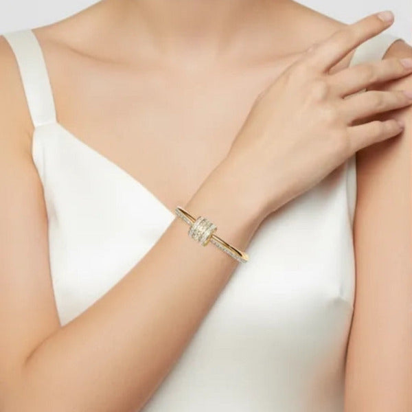 Elegant gold tone bangle bracelet, designed to adorn the wrist with a touch of sparkle.
