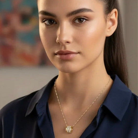 Gold plated cylindrical cubic zirconia pendant necklace. The necklace's bright finish and brilliant stones create a sophisticated and glamorous accessory suitable for various occasions.