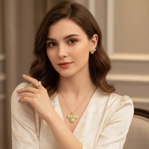 Charming jewelry set featuring the iconic Minnie Mouse head adorned with a bow, all intricately paved with clear diamonds. This set includes necklace, ring, and stud earring. It's designed to appeal to Disney fans and those looking for playful yet sophisticated accessories.