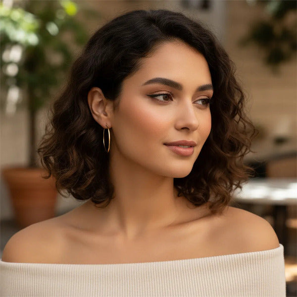 Pair of simple, elegant gold hoop earrings. Timeless and versatile piece of jewelry.