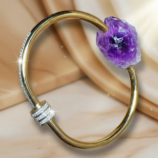 The image showcases a classic gold tone bracelet, with paved set zircon along the upper curve of the band, extending to a distinctive central ring, which is also fully adorned with these sparkling gems. 