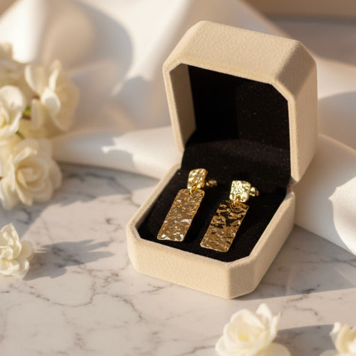 These are a pair of striking gold-toned drop earrings featuring a distinctive hammered finished.