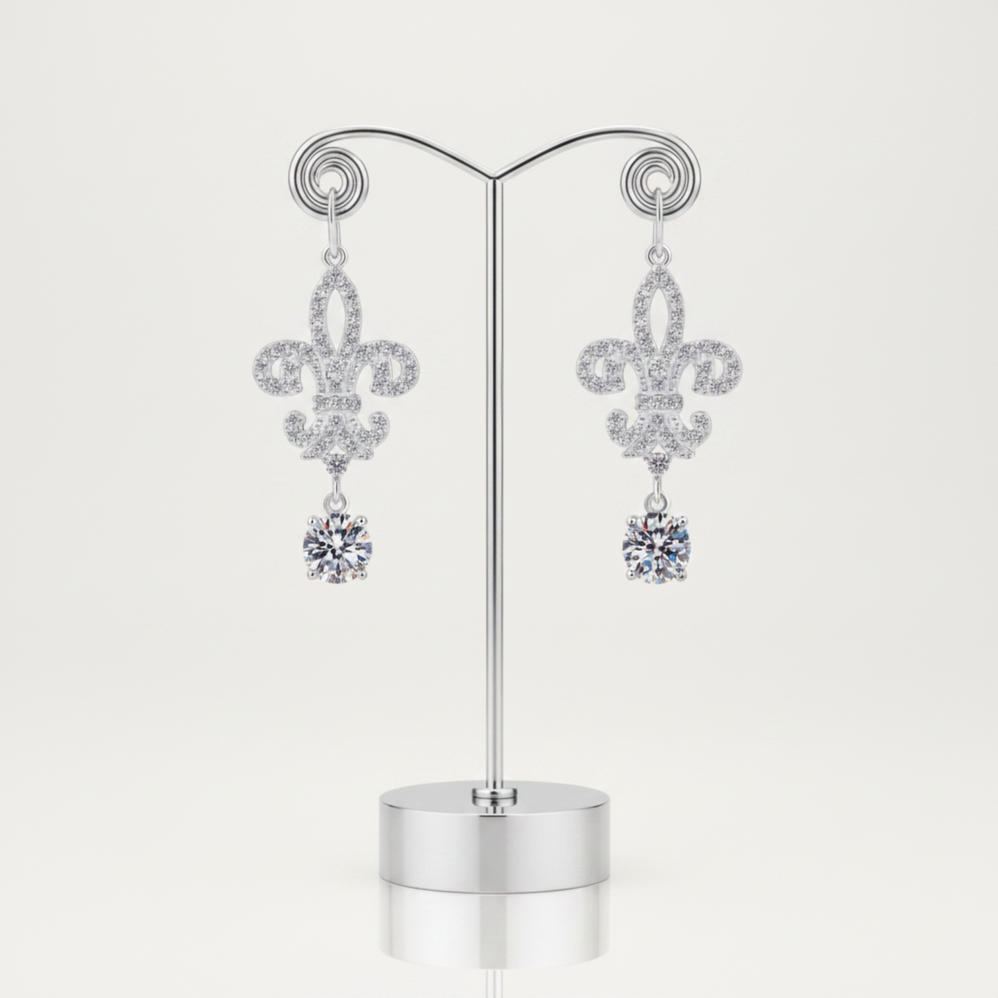 Pair of silver earrings with floral design and clear gemstones on a white background
