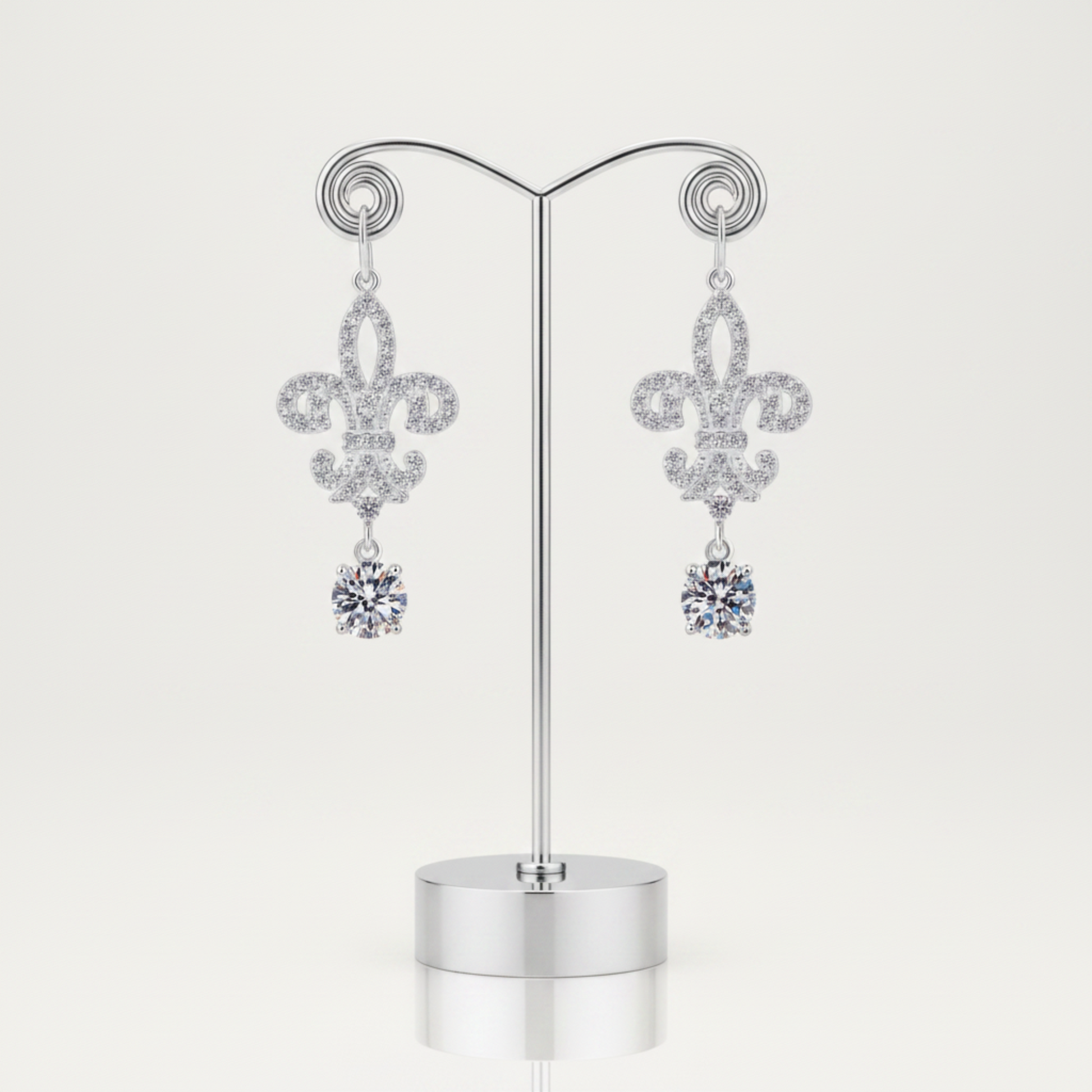 Pair of silver earrings with floral design and clear gemstones on a white background