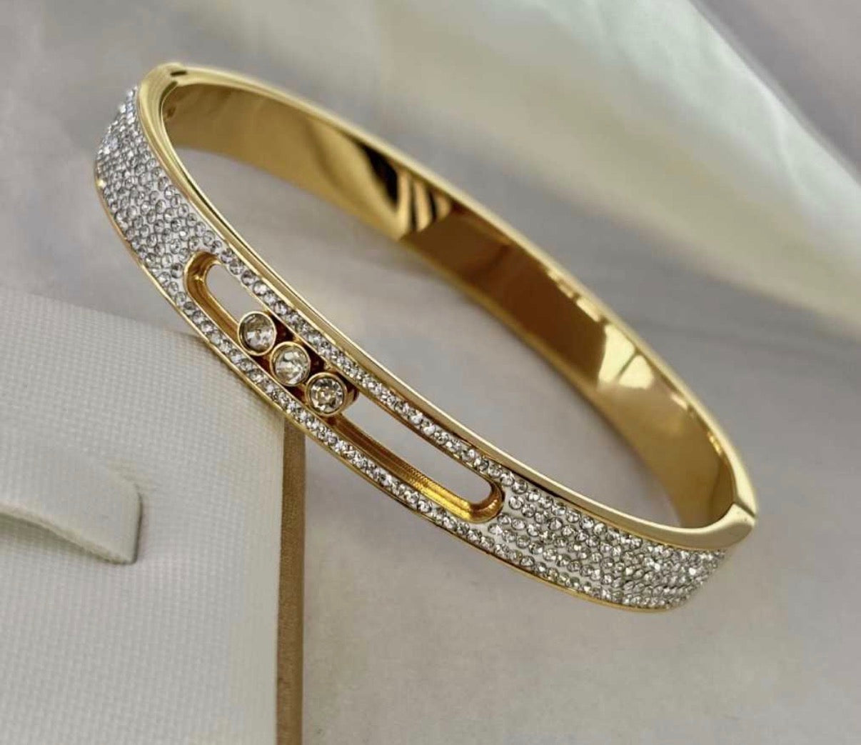 Gold bracelet with diamond accents on a white background