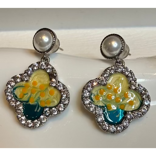 Pair of earrings with floral design and pearl-like centers on a white surface