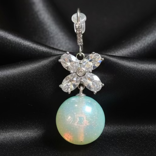 Light blue Opal silver earring with  butterfly design on a black background, showing detail of the earring