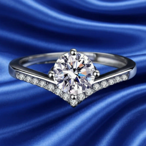 Moissanite solitary ring with a V shaped band in a blue background