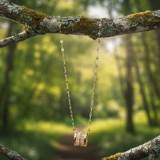 The pendant hangs from a delicate and eye-catching gold-plated chain composed of flat, elongated and twisted links, with an unique style.