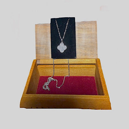 This silver version of the necklace offers a cooler and contemporary shimmer. The pendant is densely packet with small, clear stones, which creates a continuous sparkling surface.