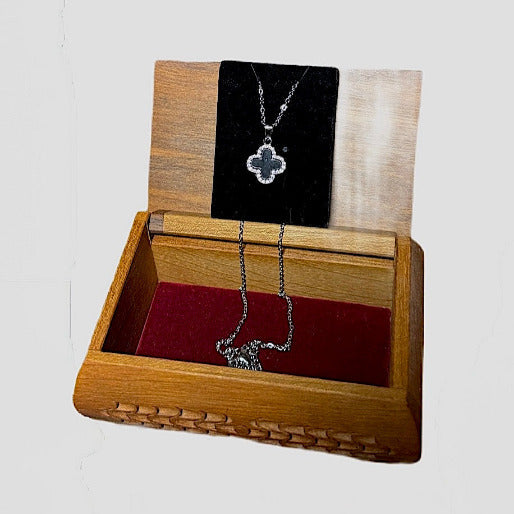 More contemporary white-gold frame with a smooth and polished black inlay pendant suspended from a matching chain.