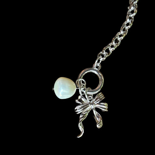 The toggle clasp not only offers a secure closure, but also adds to the bracelet's aesthetic as a decorative element, adding to the charms and enhancing the overall classic appeal.