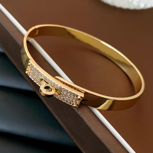 Gold bracelet with diamond accents on a brown surface