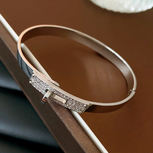 Silver bracelet with glittery accents on a brown surface