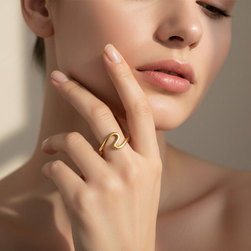The ring's open wave design, as seen on the finger, suggest a comfortable and adaptable fit. Its smooth, polished surface appears to sit flush against the skin, minimizing potential snags and making it suitable for daily wear.