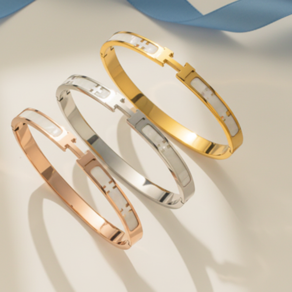 Three elegant H-design bangle bracelets in gold, silver and rose gold finishes.
