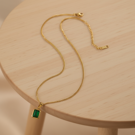 This necklace, with its classic emerald-cut green gemstone set in gold, embodies timeless elegance.