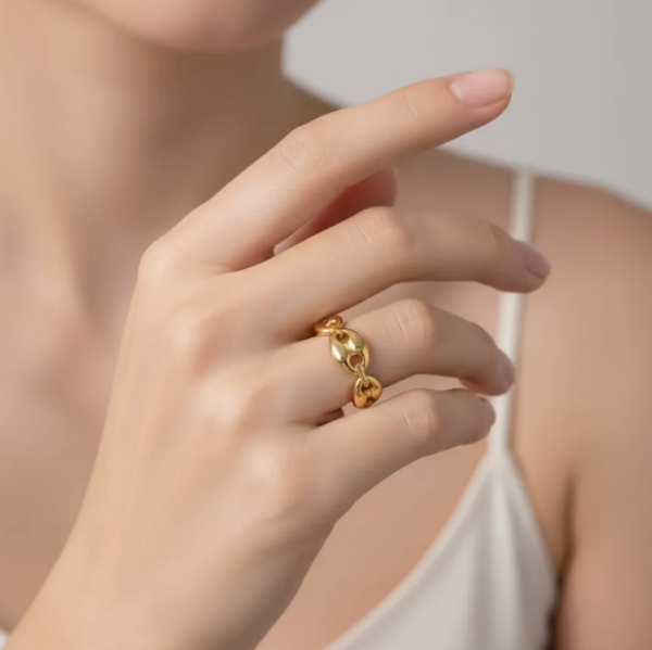 Gold ring ring on a finger. The polished finish and robust chain links give it a contemporary yet classic appeal, suitable for everyday wear or as a statement piece. 