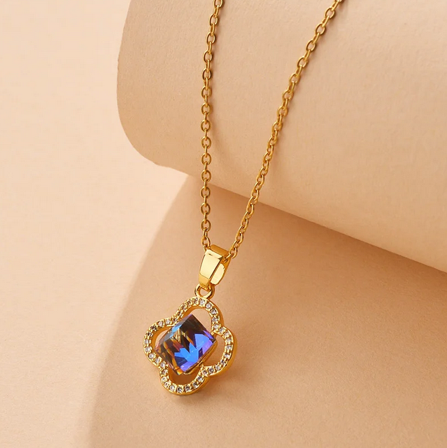 Gold necklace with a iridescent pendant. This eye-catching centerpiece is framed by a delicate border of small, sparkling clear crystals, adding a touch of glamour.