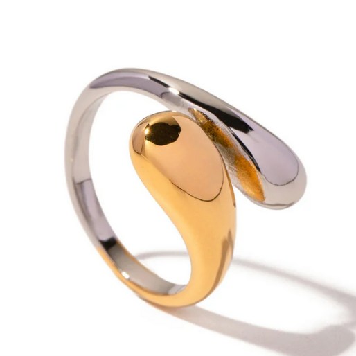 One part of the ring is a polished gold-colored element and the other is a sleek silver colored band, wrapping around each other to create a striking sculptural effect.