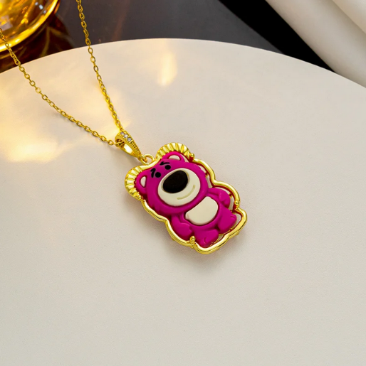 Lotso Bear Necklace, in iconic bright strawberry color with white and black facial features and a white belly patch, all outlined in gold. 