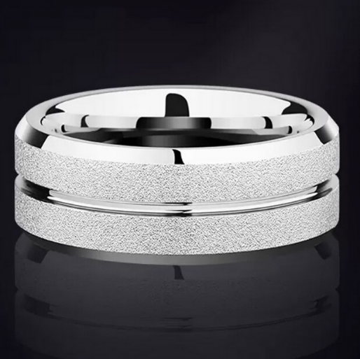 Silver ring with textured design on a black background