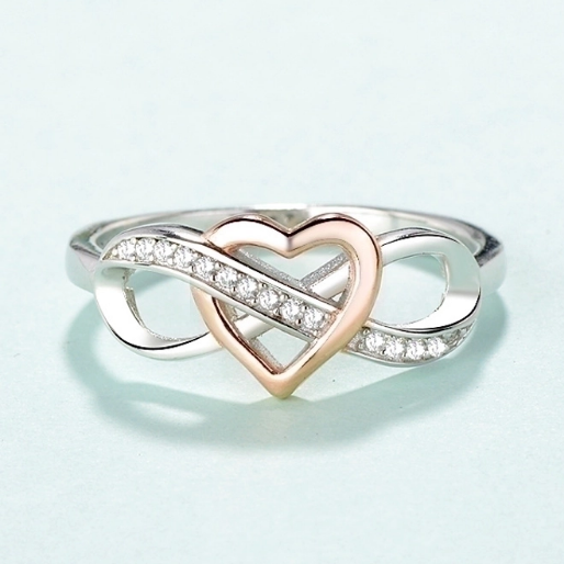 Heart-shaped ring with interlocking design on a light blue background