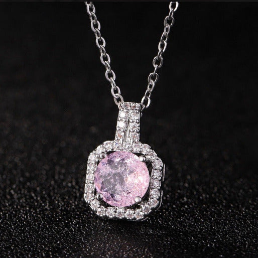 Pink gemstone pendant with silver chain on a black background