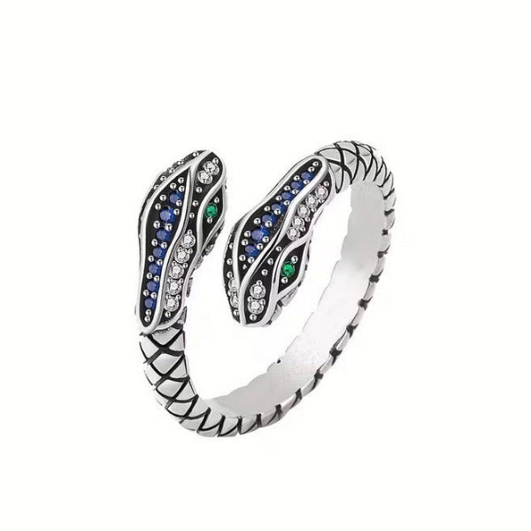 Silver ring with snake design and gemstones on a white background
