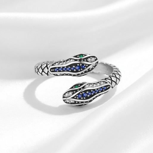 Silver snake-shaped ring with gemstones on a white background