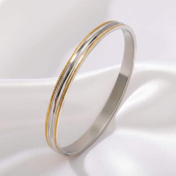 On two tone bracelet on a light beige surface with a soft focus background