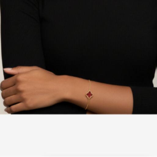 Gold bracelet with a red gemstone. Crafted in durable titanium plated on 18K gold, makes them durable, and combines with the smooth finish of the charm, conveys a sense of refined elegance that can seamlessly transition from casual daytime wear to more formal evening events.