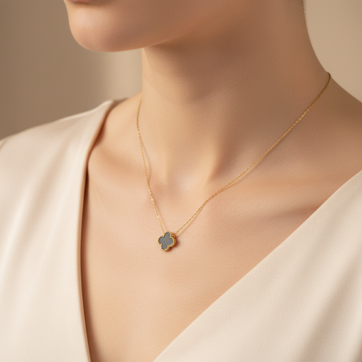 Detail of the delicate dainty chain with a solitary black clover shaped pendant. The pendant is black and framed by a fine beaded contour, giving the luxurious finish.