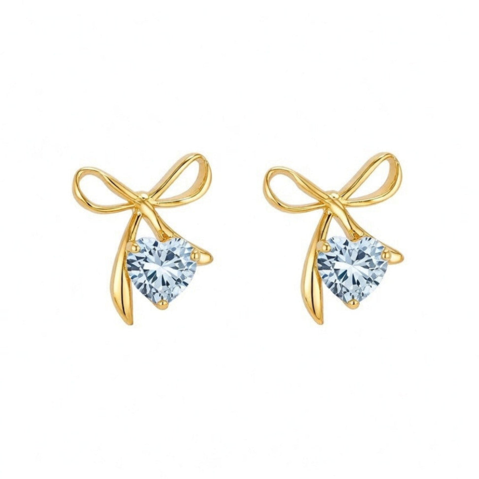 Gold bow-shaped earrings with heart-shaped gemstones on a white background