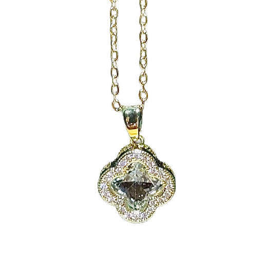 Gold necklace with a  clover pendant showcasing a prominent central stone, surrounded by smaller, sparkling accent stones. Stylish accessory often symbolizing luck and good fortune.